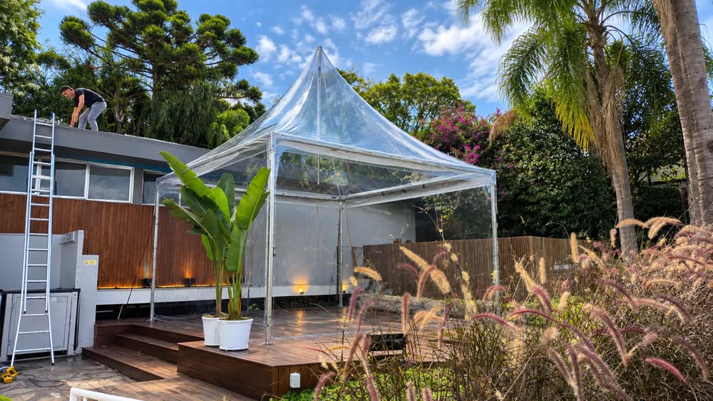 Tenda cristal sobre deck de madeira em jardim